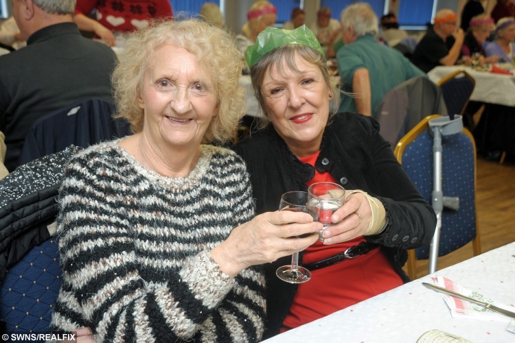 Jean Sowden (left) and Karen Knight at the Camborne Rugby Club Christmas dinner which was paid for by kind hearted solicitor Peter Campbell. See SWNS story SWLUNCH; A kind-hearted pensioner treated 50 strangers to a slap-up Christmas dinner at his local rugby club to ensure they were not alone over the festive period – and footed the £2K BILL. Retired solicitor Peter Campbell, 87, paid for the festive feast for people in his local community who would otherwise be spending the festive period alone. Generous Peter booked out his local rugby club in Camborne, Cornwall, and laid on a platter of turkey and wine, and he footed the £2,000 bill. Peter was ceaselessly thanked for his efforts, and now he intends to make the meal an annual tradition, and he said he will continue to do the event “as long as I’ve got air in my lungs”.