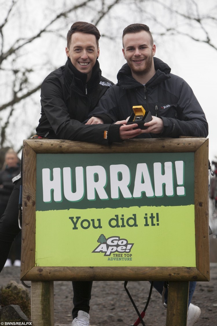 Zac Louden (R) Colin Nicholson (L) at Go Ape Aberfoyle in Queen Elizabeth Forest Park. See Centre Press story CPHAPPY; Stunned Colin Nicholson got the surprise of his life as he zoomed down a 150ft high zip wire – his partner Zac was waiting at the bottom with a “Will you marry me?” Sign. After a whirlwind romance, Zac Louden, 20, was looking for an adventurous way to propose to Colin, 31. So he decided to return to the location of their first date – Go Ape in Aberfoyle, Stirlingshire – and pop the question.